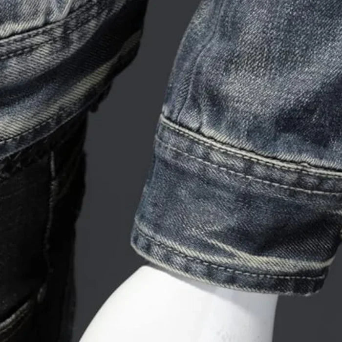 Nahaufnahme von verwaschenem, gefaltetem Jeansstoff an einer Denim-Hose auf grauem Hintergrund
