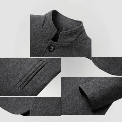 Detailansicht Herrenjacke aus dunkelgrauem Wollstoff, Stehkragen, Knopf, Reißverschlusstasche.