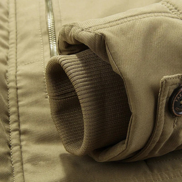Detailaufnahme einer khaki Herren Winterjacke mit Reißverschluss, Rippenbündchen und Knopf