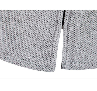 Nahaufnahme grauer Strickstoff mit Strukturmuster, Saum und Schlitz Detail.