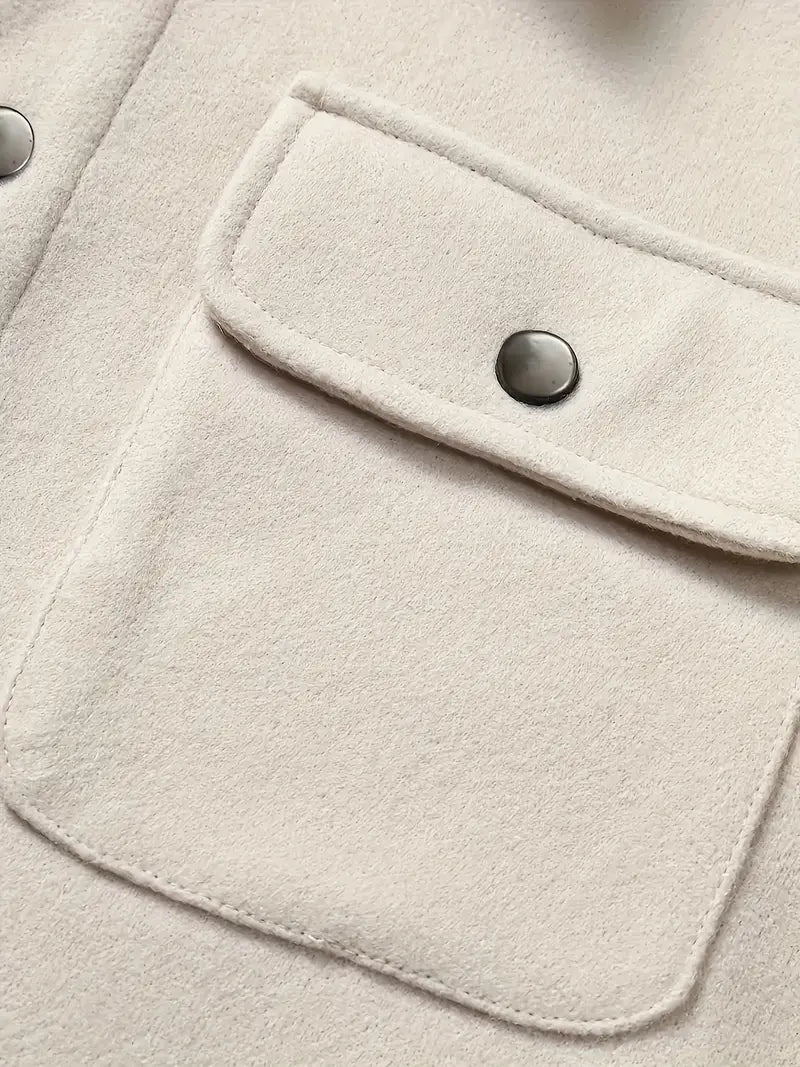 Nahaufnahme einer beigefarbenen Jackentasche mit Druckknopf auf Wollstoff