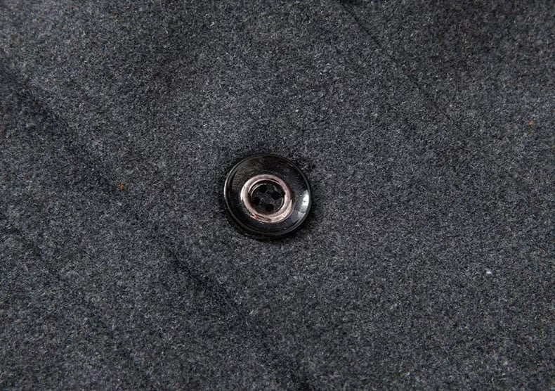 Schwarzer Knopf auf grauem Wollstoff, Detailaufnahme, Modeaccessoire Textil